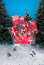 Vertical photo of market trolley pile stack newyear giftbox decoration evergreen tree snow isolated on blue color Royalty Free Stock Photo