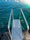 Vertical shot of metal stairs with handrails on the pier at ocean beach