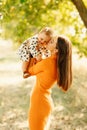 Vertical photo mother embracing her baby girl outdoors and having fan