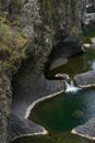 Vertical photo of natural water pools in the middle of rock formations