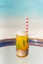 Vertical photo of new year and christmas theme tropical cocktail with straw and pine leaves on the glass on the beach Royalty Free Stock Photo