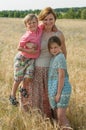 Gravid mother with children in rye field in a sunny windy day Royalty Free Stock Photo