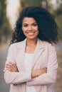 Vertical photo of pretty dark skin curly lady with crossed arms spending weekend time walking green park gold autumn Royalty Free Stock Photo