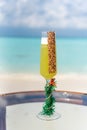 Vertical photo signature new year celebration tropical cocktail on the glass table at the beach with ocean Royalty Free Stock Photo