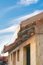 Vertical photo of small wooden house without windows and doors. Construction new building with wooden beams on the roof and wall Royalty Free Stock Photo