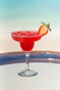 Vertical photo tasty fresh icy strawberry cocktail on the glass table at the beach with ocean Royalty Free Stock Photo