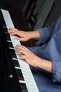 Vertical photo. Tender female hands play the piano. Photo without a face.
