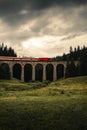 Vertical photo of train on a viaduct in the forest of Telgart -Slovakia with moody and dramatic sky before storm