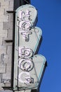 Vertical photo of vintage hot dog scalloped sign on side of stone building