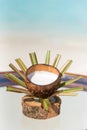 Vertical photo of virgin coconut with juice the glass table at the beach with ocean
