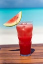 Vertical photo of Watermelon fresh juice with ice on the wooden table ocean background at the beach Royalty Free Stock Photo