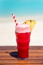 Vertical photo of Watermelon Ice Cream Soda Float cocktail with straw on wooden table with ocean background at the beach Royalty Free Stock Photo