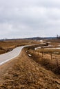 Vintage countryside small drive curves as snake at foggy grey day. Royalty Free Stock Photo