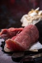 Detail of whole pork tenderloin meat on vintage board with garlic and tomatoes Royalty Free Stock Photo