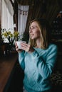 vertical photo woman drinking coffee in the morning at restaurant (soft focus on the eyes) Royalty Free Stock Photo