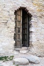 Vertical photo of a wooden open door in an ancient fortress wall in Izborsk Royalty Free Stock Photo