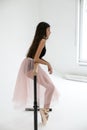 Vertical photo of a young ballerina practicing on a ballet machine in a bright studio Royalty Free Stock Photo