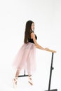 Vertical photo of a young ballerina practicing on a ballet machine in a bright studio Royalty Free Stock Photo