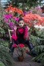 Vertical photo of a young beautiful girl surrounded by blooming azaleas