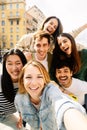 Vertical photo of young group of happy people taking selfie portrait outdoors Royalty Free Stock Photo