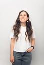 Vertical photo of a young woman is smiling and looking up in a white studio. Royalty Free Stock Photo