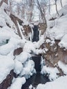 Close Up Vertical View of a Small Waterfall and Icicles Over Frozen Rocks in Winter Royalty Free Stock Photo