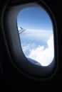 Dark Blue Sky and Clouds and an Airplane Wing and Engine Seen Through an Airplane Window Royalty Free Stock Photo