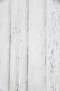 Vertical photograph of old wooden planks painted with white paint that has cracked and fallen off in places due to weather and Royalty Free Stock Photo