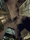 Low angle architectural view of illuminated skyscrapers reaching into a cloudy night sky in Tokyo Royalty Free Stock Photo