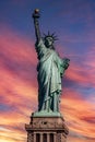 Vertical photograph of the Statue of Liberty in the Big Apple, under a reddish sky at sunrise. Royalty Free Stock Photo