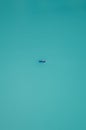 Vertical photography of a lone boat sailing at turquoise Oeschinensee in Switzerland. Swiss Oeschinen Lake. Aerial view, blurred