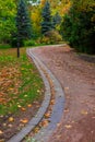 vertical photography of parkland narrow curved foot path way for walking in peaceful outdoor environment space in autumn time Royalty Free Stock Photo