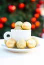 Vertical picture of coffee cup with golden Christmas balls inside and around. Coffee pair on white table angle, grey