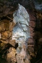 Vertical picture of a giant white stalagmite inside Postojna cave. Royalty Free Stock Photo