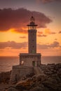 Vertical picture of the Punta Nariga lighthouse surrounded by the sea during the sunset in Spain Royalty Free Stock Photo
