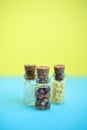 Vertical picture with soft focus of three tiny glass jar with buckwheat, millet, sugar on blue and yellow background, top view. Royalty Free Stock Photo