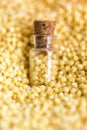 Vertical picture with soft focus of tiny corked glass jar with millet on background from millet, top view. Concept of healthy Royalty Free Stock Photo