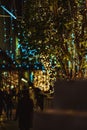 Vertical picture of a tree decorated with Christmas lights on the street during the night Royalty Free Stock Photo