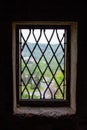 Vertical picture of the view of the green trees of the mountain of Loket, in Czech Republic, through the grills of a window from Royalty Free Stock Photo