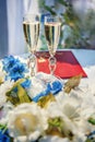 Vertical picture of wedding glasses with champagne, bride and groom rings and wedding decorations in summer sunny wedding day. Royalty Free Stock Photo