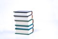 Vertical pile of books on white background. Image contains copy space