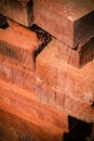 Vertical pile red, brown brick piled in a stack closeup for construction building background