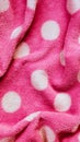 Vertical pink delicate soft background of fur plush smooth fabric with white circles. Texture of light red soft fleecy blanket Royalty Free Stock Photo