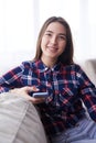 Pleased girl sitting on sofa with telephone Royalty Free Stock Photo