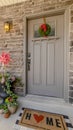 Vertical Porch of a home decorated with wooden chair potted plants wreath and doormat