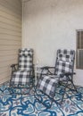 Vertical Porch of a house with two lounge chairs and carpet with blue and white colors