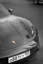 Vertical of Porsche parked on the street shot in grayscale