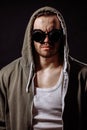 Vertical portrait of angry young man wearing green hoodie and glasses Royalty Free Stock Photo