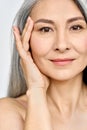 Vertical portrait of Asian mature woman& x27;s face with perfect skin.