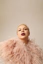 Vertical portrait of beautiful blond young woman wearing pink marabou feathers. Royalty Free Stock Photo